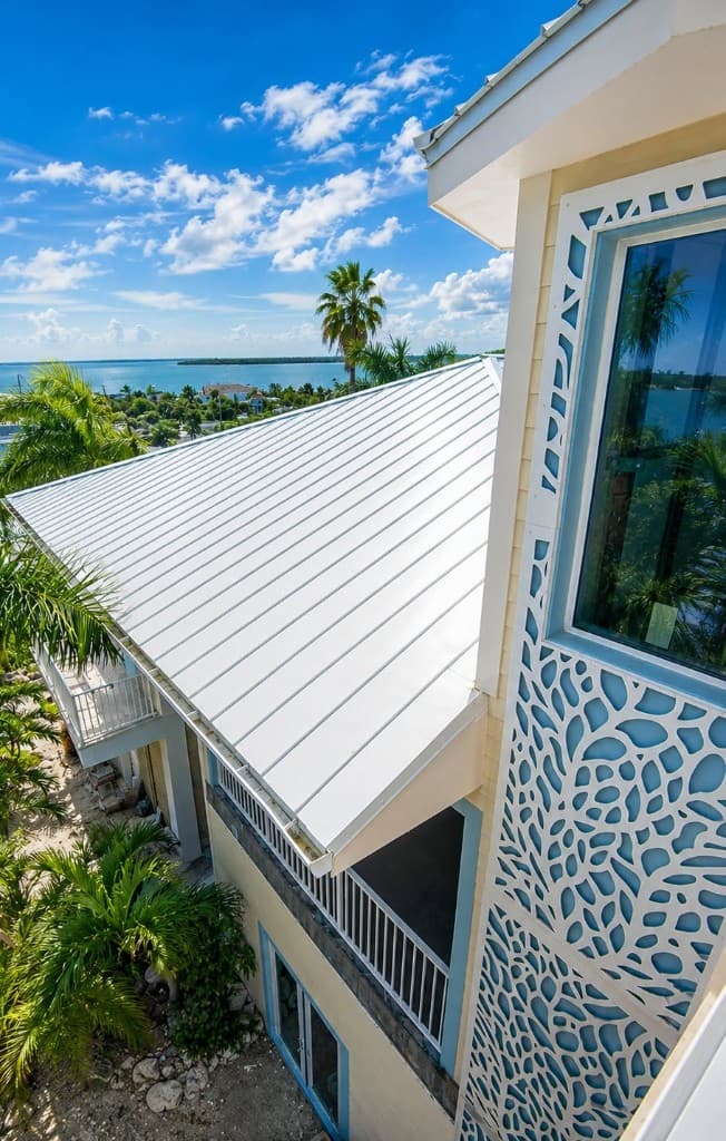White standing-seam metal roof on a coastal Florida home overlooking the water